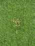 The image shows a gold-colored cake topper with the word "hello" and the number "33" styled in a decorative script. The topper is placed against a backdrop of artificial green grass. The design is intended for use in cake decoration, possibly for a celebration.