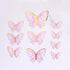 A set of five butterfly cake toppers in various sizes, featuring a pink and gold design. The butterflies have delicate outlines and a marbled pink appearance with metallic gold accents around the wings. The arrangement includes one large butterfly at the top and several smaller butterflies in a cluster below it. The background is plain and light-colored.