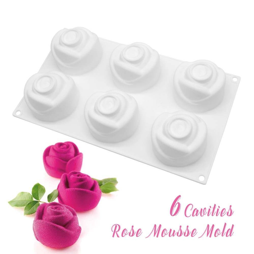 A white silicone mold shaped like rose flowers, featuring six cavities for creating rose-shaped desserts. Three vibrant pink rose desserts with green leaves are placed beside the mold. The text "6 Cavities Rose Mousse Mold" is displayed in a playful font.