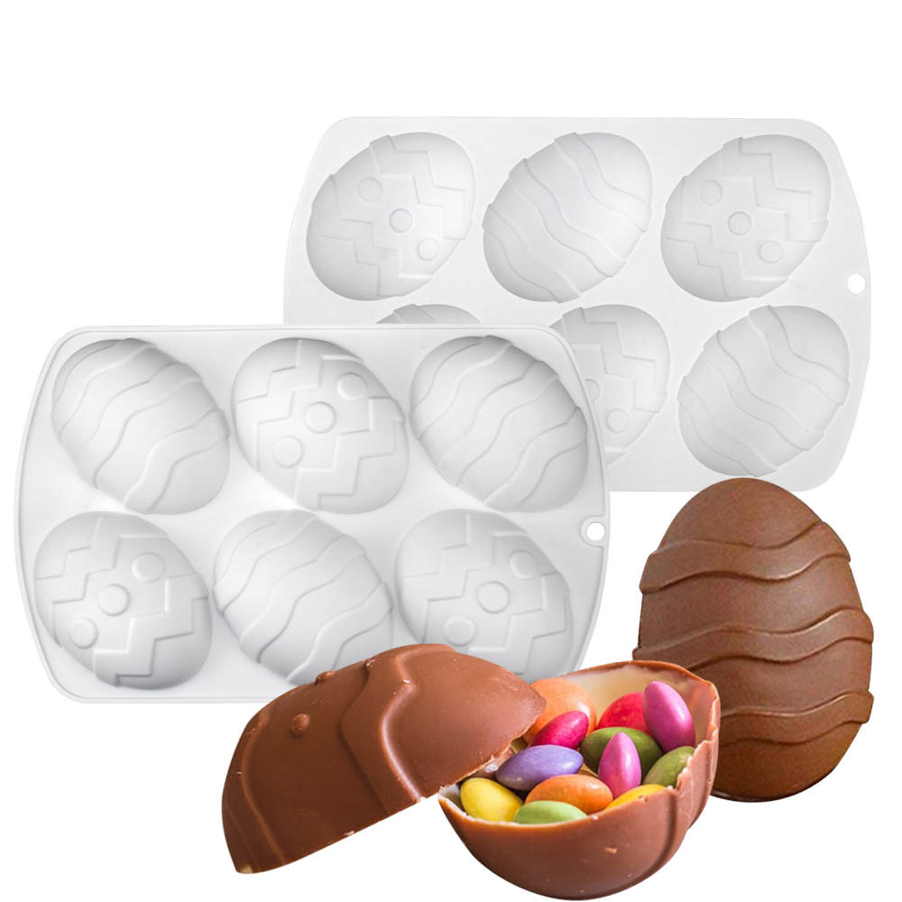 An image featuring a white silicone mould designed to create egg-shaped chocolates. The mould displays six cavities with decorative patterns resembling Easter eggs. In the foreground, a chocolate egg is shown in two halves, revealing colorful candy inside, emphasizing the product&