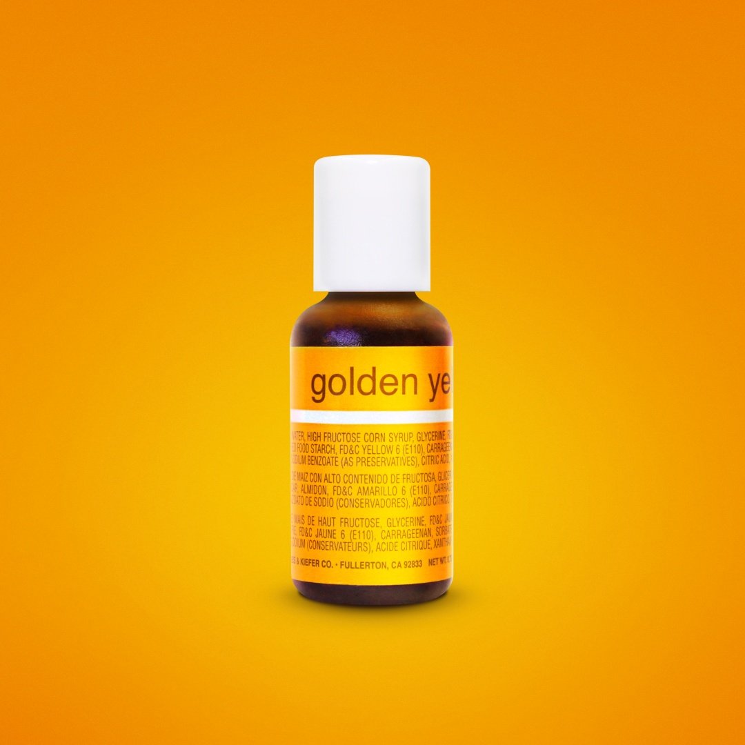 A bottle of Chefmaster Liqua Gel Color in Golden Yellow, 0.7 oz (20 ml). The bottle has a white cap and a brightly colored yellow label that features the text "golden ye" along with ingredient information in English and Spanish. The background is a solid orange color.