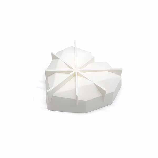 A heart-shaped pinata mold made of white plastic. The mold has a segmented design with triangular sections radiating from the center, resembling a geometric pattern. The base is flat with slight elevation along the edges, suitable for creating a pinata.