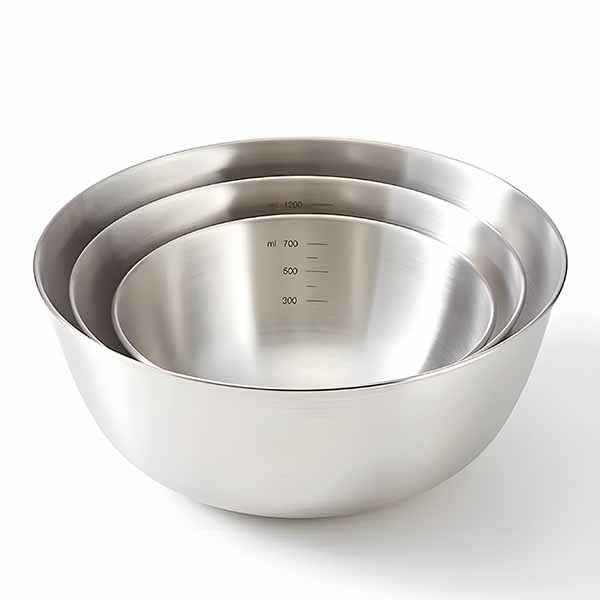 Three stainless steel mixing bowls of varying sizes are stacked together. The largest bowl is on the bottom and has a smooth, shiny surface. The middle bowl is slightly smaller and also features a shiny finish. The smallest bowl sits in the center and has measurement markings inside, indicating milliliters (300, 500, 700, and 1000 ml). The bowls have rounded edges and a polished appearance, suitable for mixing and serving.