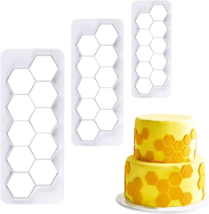 The image features three hexagon cookie cutters of varying sizes, arranged vertically on the left side. Each cutter has a series of hexagonal shapes cut out. To the right, there is a two-tiered yellow cake decorated with hexagonal patterns that match the shape of the cookie cutters. The cake has a smooth yellow surface with scattered hexagonal accents in a slightly darker shade. The background is a neutral color, emphasizing the cookie cutters and the cake.