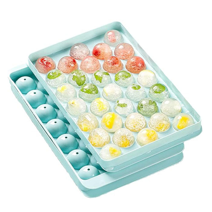 A light blue round ice cube tray featuring various colored ice cubes. The top section contains colorful ice spheres, some with pieces of fruit or herbs visible inside. The bottom section shows unfilled round cavities for future ice cubes. The overall design is modern and practical for making round ice.