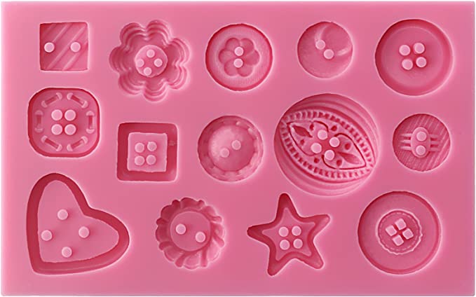 The image displays a pink silicone mould designed for creating button shapes. The mould features various button designs, including round buttons, a star-shaped button, a heart-shaped button, and flower-shaped buttons, each with distinctive patterns. There are also square and oval shapes, all with two or four small holes to resemble classic button features. The overall layout consists of 15 different button designs arranged neatly within the mould.
