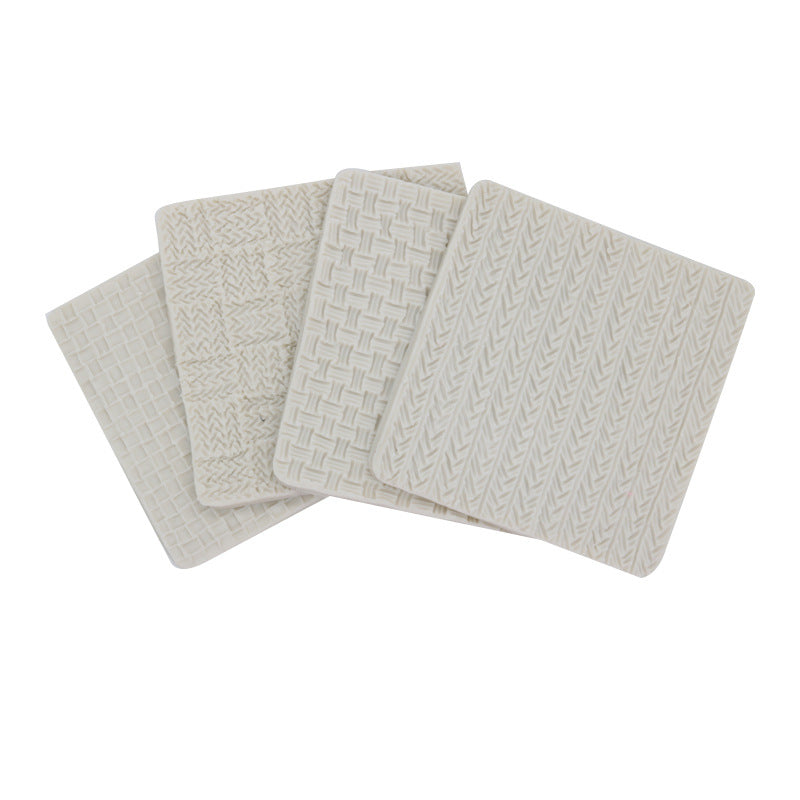 A set of four square silicone molds in a light color, each featuring different textured patterns resembling knitting designs. The molds include a crisscross weave pattern, a basket weave pattern, and two additional knit-like textures. They are arranged in a slightly overlapping manner.