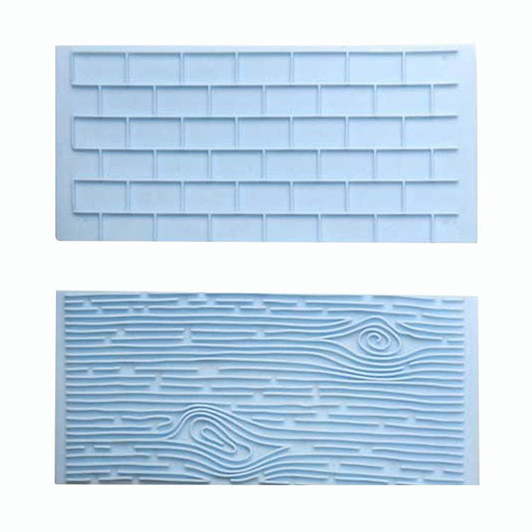 The image displays a two-piece set of silicone impression moulds designed for crafting. The top mould features a textured pattern resembling a brick wall, characterized by rectangular shapes arranged in a grid. The bottom mould showcases a design that mimics the texture of tree bark, with wavy lines and swirls that represent the natural grain and patterns found in wood. Both moulds are light blue in color, highlighting their detailed impressions.