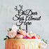 A colorful cake topped with an acrylic cake topper that reads "Oh Deer She&