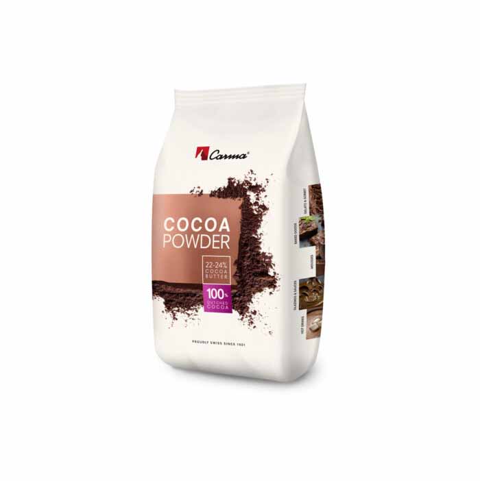 A white bag of Carma cocoa powder weighing 1 kg. The front features the text "COCOA POWDER" prominently displayed in large letters, along with information about the cocoa content (22-24% cocoa butter) and a note indicating it is made from 100% pure cocoa. There are images of chocolate desserts beside the text, enhancing its appeal for baking or cooking. The bag is designed in a clean and modern style.