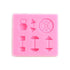 A pink silicone mold featuring various fitness-shaped cavities. The mold includes shapes of a kettlebell, a dumbbell, a barbell with weights, and a circular weight plate, all designed for making treats or candies in the shape of gym equipment.