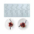 A silicone mold with six hollow branch-shaped cavities, designed for creating intricate edible decorations. Two plated desserts with chocolate branch designs are displayed below, demonstrating creative plating ideas.