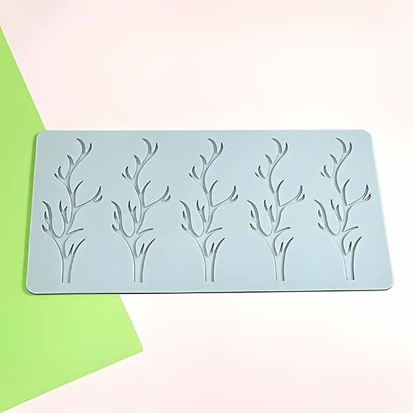 A close-up of the silicone mold featuring six hollow branch-shaped designs, displayed on a clean background with vibrant green accents, emphasizing its detailed craftsmanship and unique design.