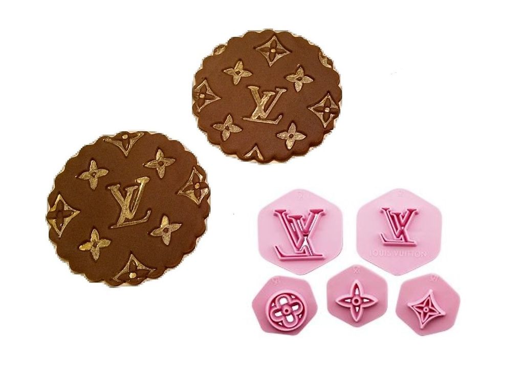 The image features a product set called the "LV Fondant Embosser Cutter Set of 5." It includes two circular fondant pieces in a brown color, embossed with a pattern that resembles a luxury brand logo, surrounded by floral designs. Additionally, the set contains five pink plastic cutters, each with different shapes: two feature the logo, while the others depict floral motifs, all in geometric shapes. The items are displayed against a plain background for clarity.