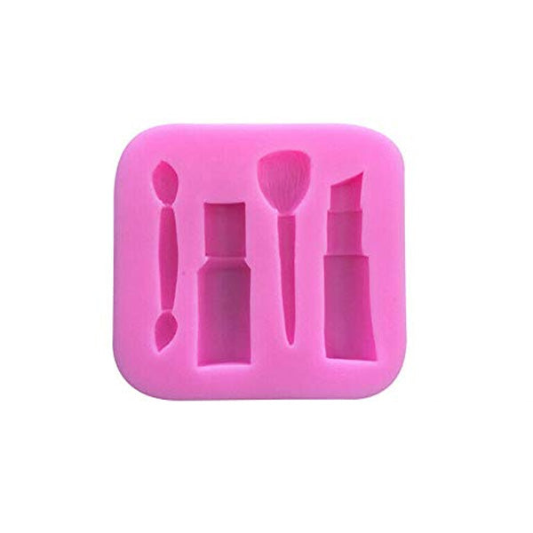 A square pink silicone mold designed for makeup items, featuring impressions of a makeup brush, a lipstick tube, and a small rectangular container, along with a small applicator tool.