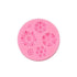 A circular, pink silicone mold designed for creating mini flower shapes. The mold features various floral designs, including different sizes and types of flowers, each with intricate details. The flowers are raised in relief, showing textures typical of petals and centers, making it suitable for baking or crafting purposes.