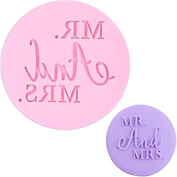 The image features two fondant embosser cookie stamps. The larger stamp, in pink, has the text "MR. And MRS." in a decorative font, with the words positioned in a slightly curved arrangement. The smaller stamp, in purple, features the text "MR And MRS." in a similar script style. Both stamps are circular in shape and are designed for embossing onto cookies or fondant.