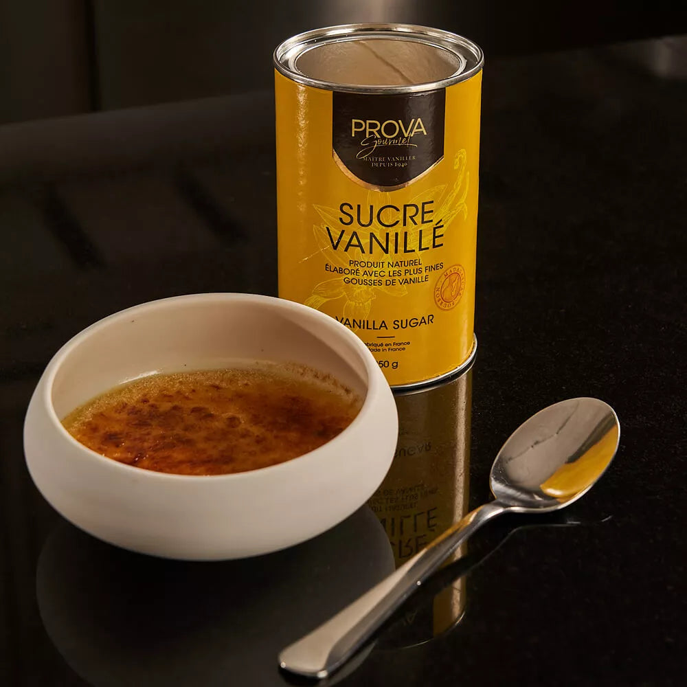 Can of Prova Vanilla Sugar next to a bowl of vanilla sugar on a dark surface