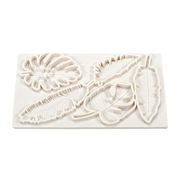 A white silicone mold featuring five different tropical leaf designs. The mold includes a large monstera leaf, a pair of elongated palm leaves, a smaller leaf with pronounced veining, and a leaf with a rounded shape. The leaves are intricately detailed, showcasing their texture and outlines within the mold. The overall shape of the mold is rectangular.