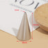 "A metallic piping nozzle with a pointed tip, measuring 1mm at the opening, 35mm in height, and 18mm in diameter at the base. The nozzle is placed on a flat surface with a light background, alongside a wooden plate and partially visible text on paper."