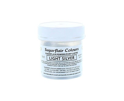 The image shows a small jar of Sugarflair Colors edible glitter dust powder. The jar is labeled "Light Silver" and contains 25 grams of the product. The container is primarily white with a clear lid, and the label includes details about the product type and usage instructions.