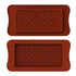 The image shows two silicone moulds for making chocolate bars, both designed with a pattern of small hearts. The moulds are rectangular in shape, with rounded edges and a textured heart design covering the surface. The top mould is positioned above the bottom mould, and both have a similar heart pattern, creating a decorative effect for the chocolate bars. The colour of the moulds is a rich, reddish-brown.