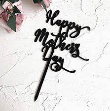 A black acrylic cake topper featuring the cursive text "Happy Mother&