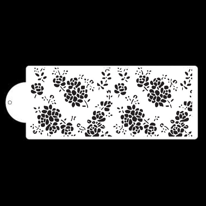 The image features a cake stencil, labeled "Cake Stencil ST 5474." The stencil is white and has a decorative design consisting of various floral patterns. The flowers and leaves are cut out, creating a lace-like effect that allows for decoration when used with icing or dusting powders. The stencil includes a rounded cutout on the left side for easy handling. The background is black, emphasizing the intricate floral design of the stencil.