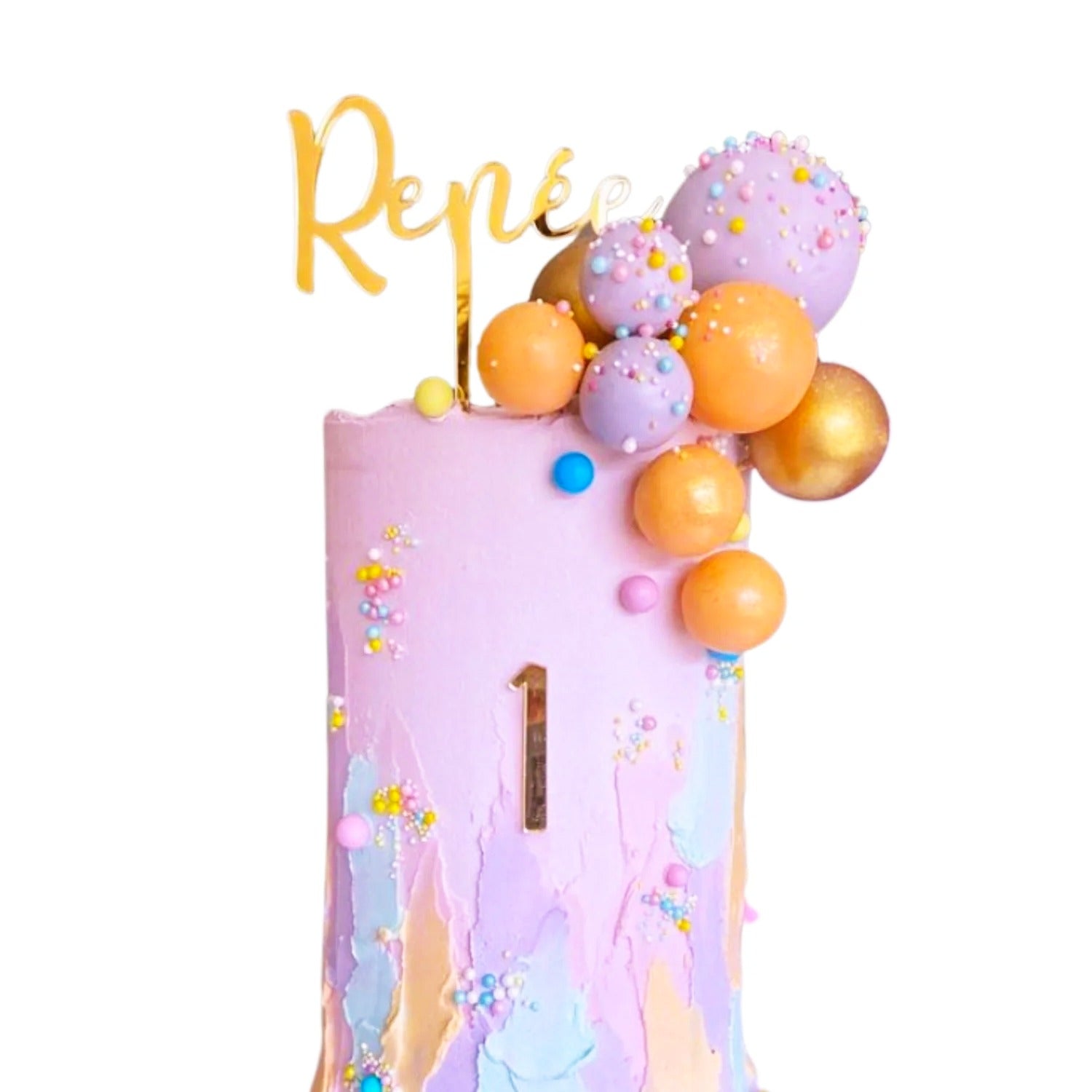 The image features a colorful birthday cake decorated with a variety of elements. At the top, there is a golden topper that reads "Renee." The cake itself has a pastel pink frosting base with a large number "1" prominently displayed on the front. The sides of the cake are adorned with numerous round cake decorations in shades of purple, orange, and gold, along with small, colorful sprinkles scattered throughout. The overall design is vibrant and festive, perfect for a birthday celebration.