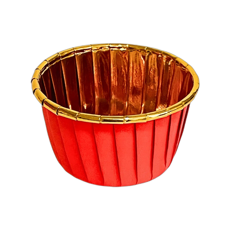 Red pleated cup with a gold interior and rim, set against a black background. The shiny surface and warm colors create an elegant, festive tone.