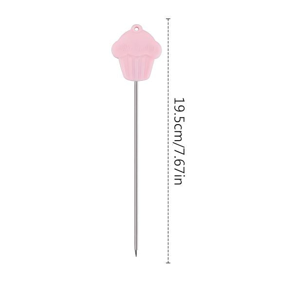 A stainless steel cake tester needle with a pink cupcake-shaped plastic handle. The total length of the tester is 19.5 cm (7.67 inches), illustrated with a vertical line showing its measurement.