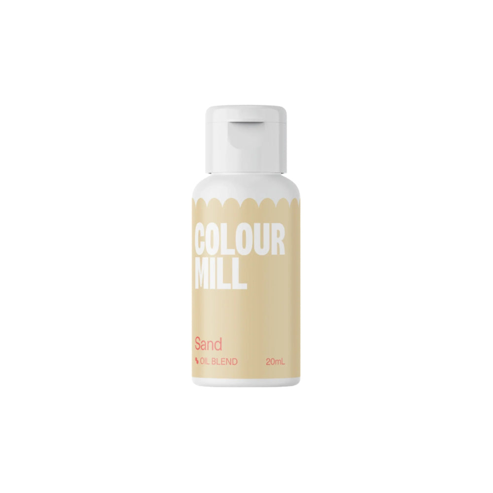 A 20ml bottle of Colour Mill oil-based food color labeled "Sand." The bottle has a white cap with a rounded edge, and the body is colored in a soft sand-like beige with white text reading "COLOUR MILL" prominently displayed. Below that, the word "Sand" is printed in pink, followed by ?OIL BLEND? and "20ML" in smaller text. The background is black.