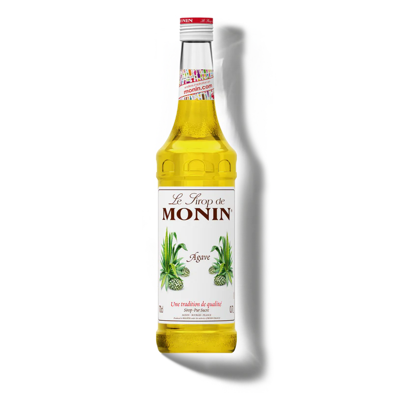 A bottle of Monin Agave Syrup stands against a black background. The label features green agave illustrations, and the liquid inside is golden yellow.