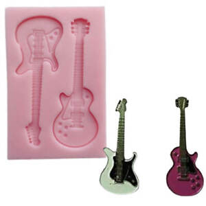 A pink silicone mold shaped like two guitars, with one guitar on the left appearing in a light pink color and the other in a darker pink. Next to the mold are two small guitar figurines, one silver and one dark pink, showcasing the products that can be made using the mold.
