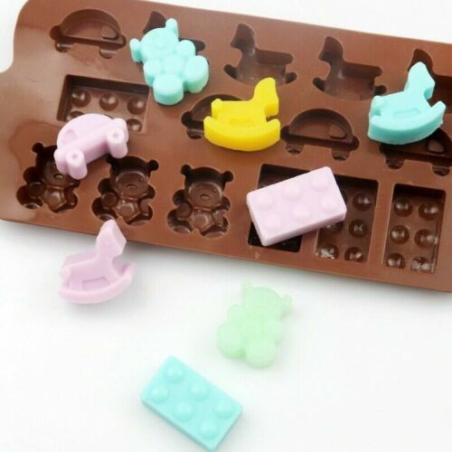 A silicone mould featuring various shapes, including a rocking horse, bears, toy cars, and building bricks. The mould itself is brown and contains colorful silicone toys in pastel shades: light blue, yellow, pink, and green. Some of the completed toys are placed around the mould, showcasing their playful designs.