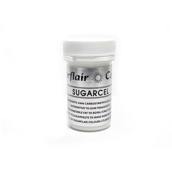 A clear container of Sugarflair Sugarcel Tylose Powder (14g) with a white lid. The label on the container has "Sugarflair" at the top, followed by "SUGARCEL" prominently displayed. It lists ingredients and uses, indicating it contains E466 (Carboxymethylcellulose) and serves as an alternative to gum tragacanth. The container is set against a plain white background.