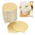 Image shows a stack of round, gold mini cake boards, each measuring 10 cm in diameter. Two boards are placed in the foreground, highlighting their shiny finish. In the background, a small cake is displayed on a matching gold board, featuring a mint leaf on top. The setting appears to be a wooden surface.