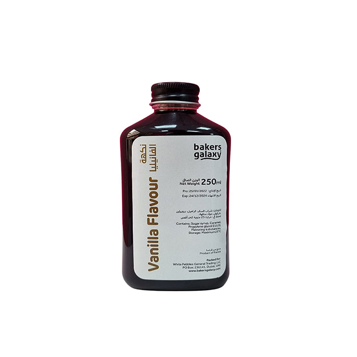 A dark amber-colored bottle labeled "Vanilla Flavour" with a capacity of 250 ml. The label includes the product name in both English and another language, along with information about the contents and storage instructions. It features the brand name "bakers galaxy" on the top. The bottle has a black cap and a slightly curved shape.