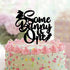 A pastel-colored cake topped with pink frosting, colorful sprinkles, and a black acrylic cake topper that reads "Some Bunny is One." The topper features a silhouette of a bunny and a carrot.