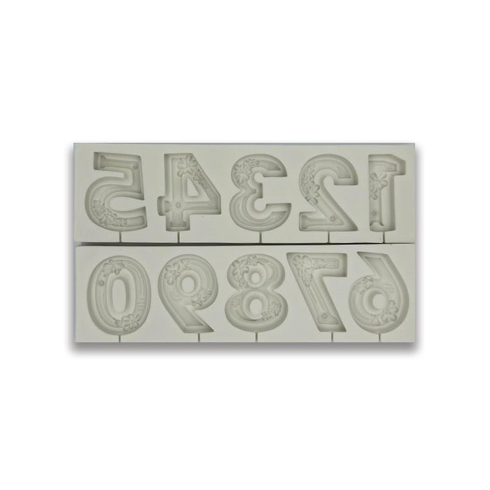 The image shows a silicone mold containing numbers. The mold features the digits 0 to 9, arranged in two rows. Each number has decorative floral designs imprinted on its surface. The mold is light-colored and has a glossy finish, suitable for creating cake toppers or other edible decorations.