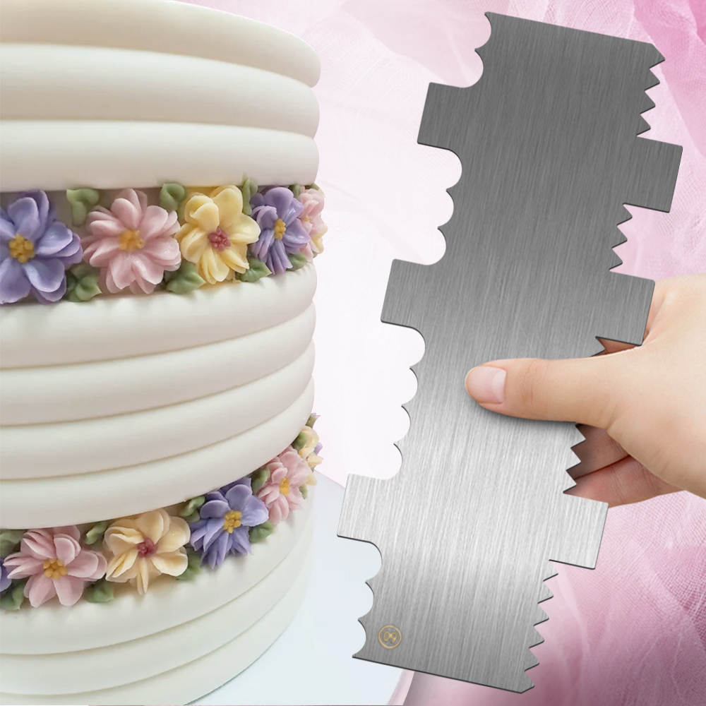 An image featuring a stainless steel scrapper being held in a hand on the right, with a close-up of a decorated cake on the left. The cake has smooth white fondant layers and is adorned with colorful, fondant flowers in shades of pink, yellow, and purple, arranged around the base of the layers. The scrapper has a shiny metallic surface and a unique edge design for cake smoothing or decorating.