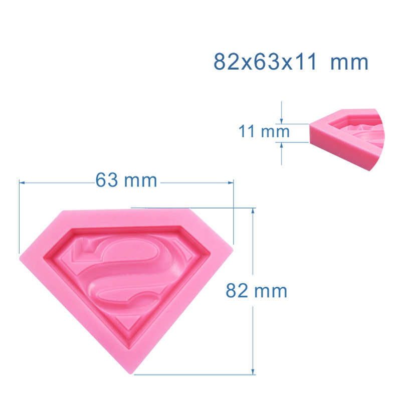 A pink silicone mould in the shape of a diamond featuring the Superman logo. The dimensions of the mould are displayed as 82 mm by 63 mm with a depth of 11 mm. The mould has a 3D design with the iconic "S" emblem prominently featured in the center.