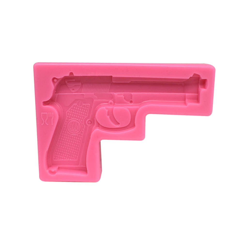 A pink silicone mold shaped like a pistol, designed for creating 3D gun-shaped items. The mold features intricate details of the firearm, including the grip and trigger. It has a flat base and raised sections that define the shape of the gun.