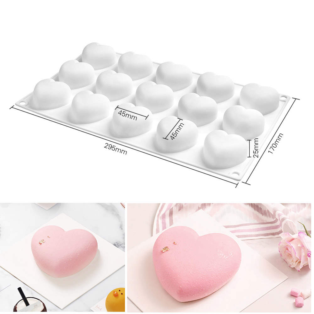 The image features a rounded heart silicone mold designed for baking or crafting, with 15 cavities shaped like hearts. The mold is white and measures 295mm in length, 170mm in width, and 25mm in height. Each heart cavity has a measurement of 45mm. Below the mold, there are two photographs of heart-shaped desserts. One dessert is pink and smooth, placed on a white square plate, while the other has a decorative touch and is surrounded by a striped cloth and flowers.