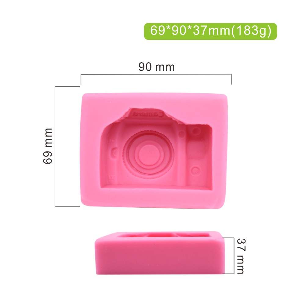 An image of a pink silicone mould designed in the shape of a 3D camera. The mould features a detailed camera design, including a circular lens and other camera elements. The dimensions of the mould are indicated as 69 mm in height, 90 mm in width, and 37 mm in depth, with a weight of 183 grams. The mould is displayed from an angle that shows both the front design and the flat base.