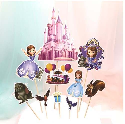 A collection of colorful cake toppers featuring a pink princess castle, various cartoon characters including two princesses in blue and purple dresses, a birthday cake with balloons, a gift box, and animals such as a rabbit and a squirrel. All toppers are mounted on wooden sticks and set against a soft, pastel background.