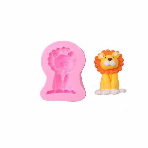 A pink silicone mould shaped like a lion sits next to a completed lion figure. The figure has a yellow body, a fluffy orange mane, and a white belly, appearing cute and cartoonish. The mould shows the lion&