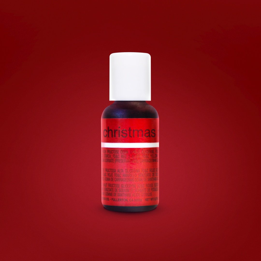 A bottle of Chefmaster Liqua-Gel Color in Christmas Red, 0.7 oz (20 ml), featuring a white cap and a label that reads &quot;christmas&quot; in bold red on a darker red background. The label includes various ingredients and information, but the text is mostly obscured by the focus on the product. The overall setting has a solid red background.