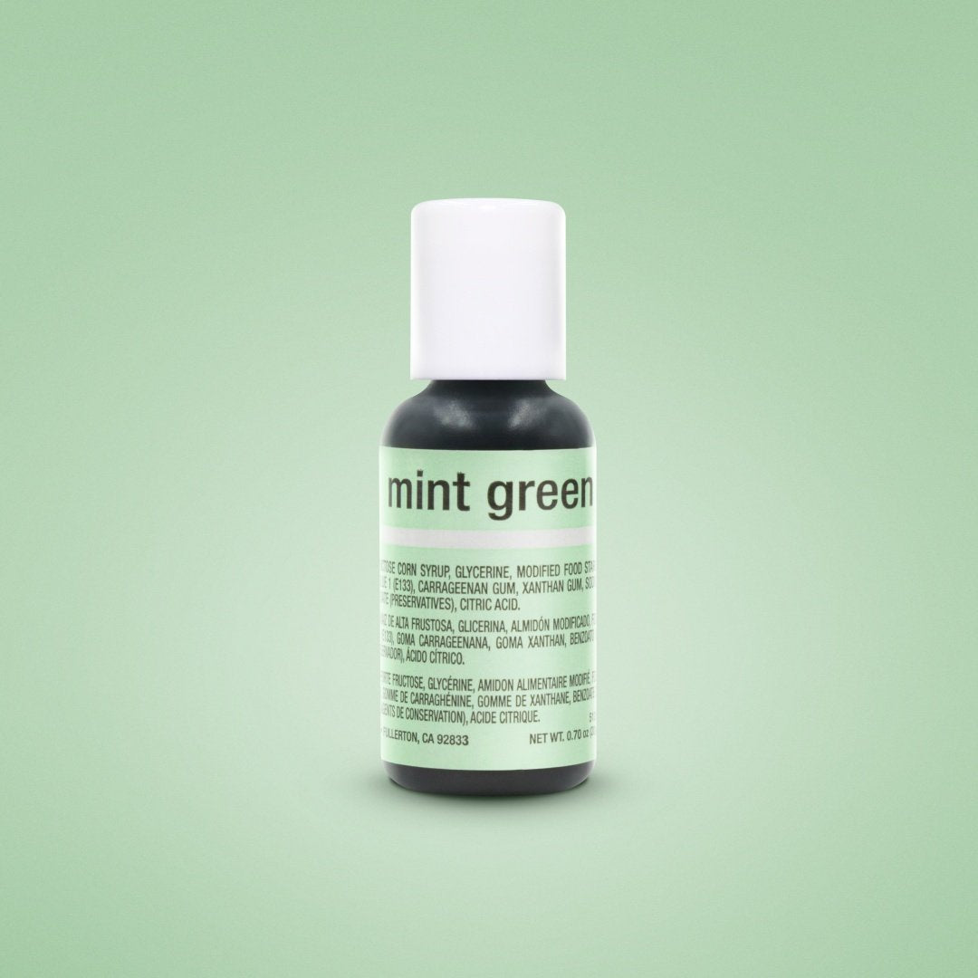 Product image of Chefmaster Liqua Gel Color in mint green, featuring a 0.7 oz (20 ml) squeeze bottle with a white cap. The label displays the product name &quot;mint green&quot; prominently, with ingredient details printed in multiple languages on the side. The background is a soft green color.