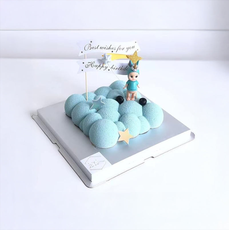 A cake adorned with a blue cloud and a small boy figurine, adding a charming touch to the dessert.
